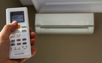 Close-up of a hand holding a remote control for a ductless mini split air conditioner.