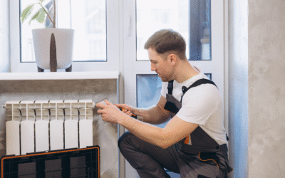A technician repairs a heating radiator in a residential apartment.