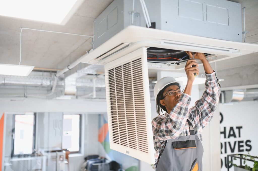 A technician is working on an air conditioning unit.