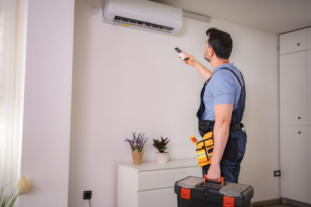 A technician is using a remote to control the ac unit.