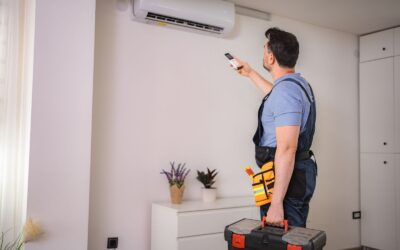 A technician is using a remote to control the ac unit.